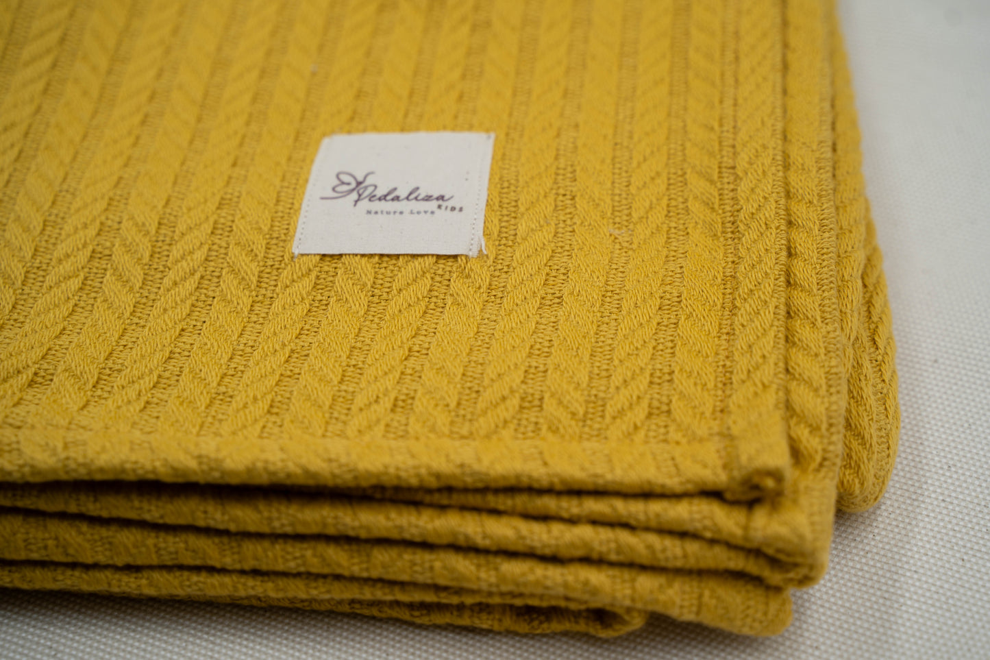 Babydecke im Zopfstrick-Muster in Senfgelb