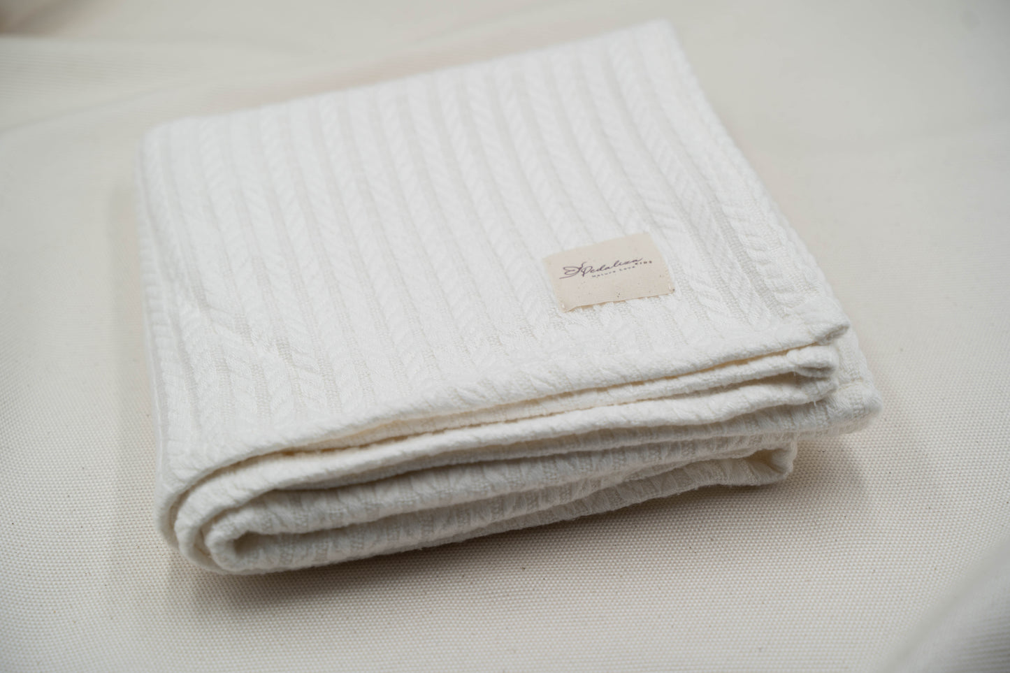 Babydecke im Zopfstrick-Muster in Creme