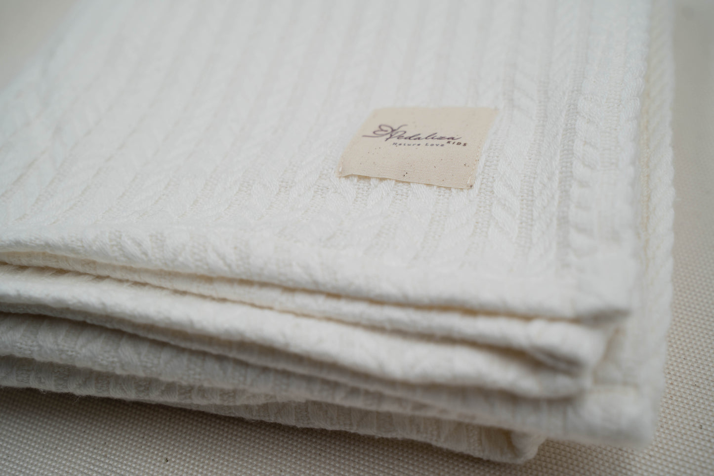 Babydecke im Zopfstrick-Muster in Creme